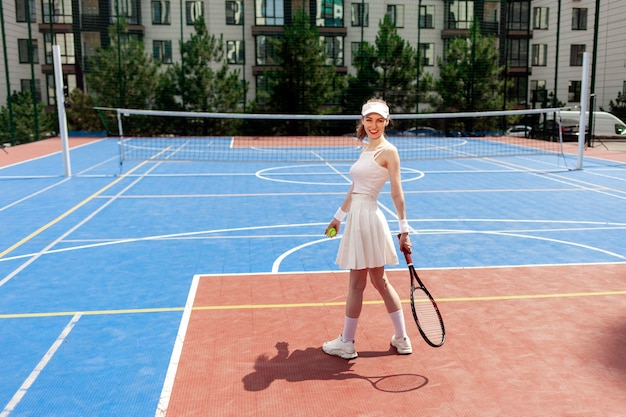 young girl tennis player in uniform holding racket on tennis court female athlete playing tennis