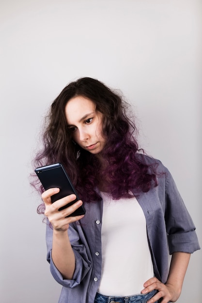 Young girl thoughtfully looks in phone