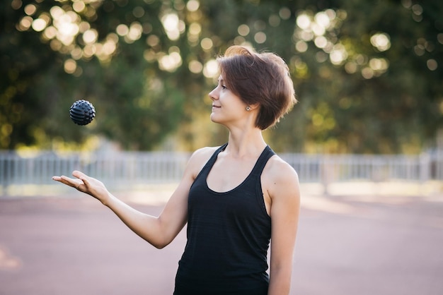 young girl throws a massage ball in her hands