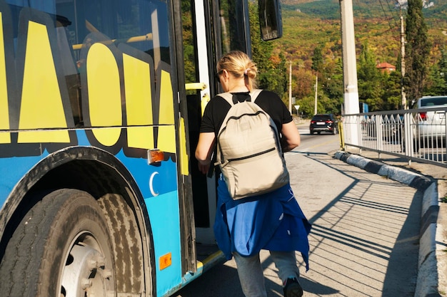 Young girl tourist enters bus