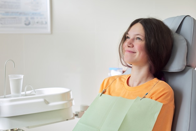 치아 치료, 치과 의사의 자에 앉아 여성 십 대를 치료하는 어린 소녀