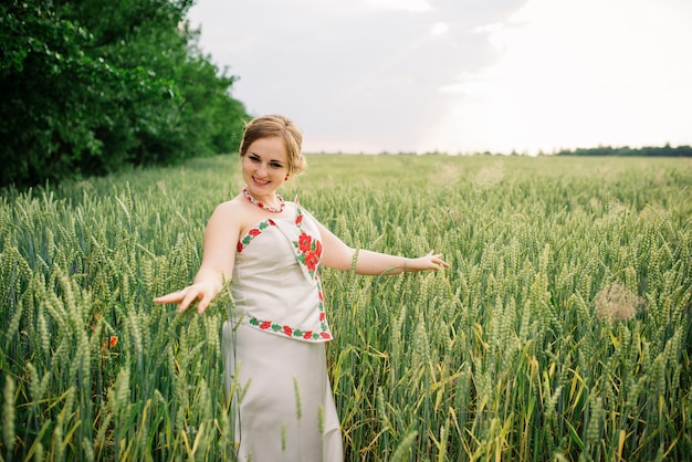 Young girl at ukrainian national dress posed at wreath field.