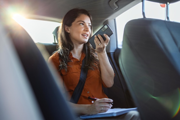 Young girl uses a mobile phone in the car Technology cell phone isolation Internet and social media Woman with smartphone in her car Girl is using a smartphone in car
