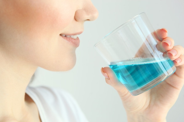 Young girl uses mouthwash at home closeup