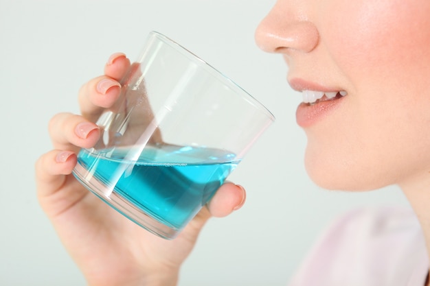 Young girl uses mouthwash at home closeup