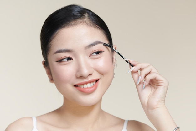 눈썹에 브러시를 사용하는 어린 소녀