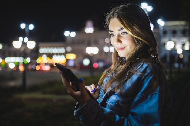 young girl using digital tablet at night