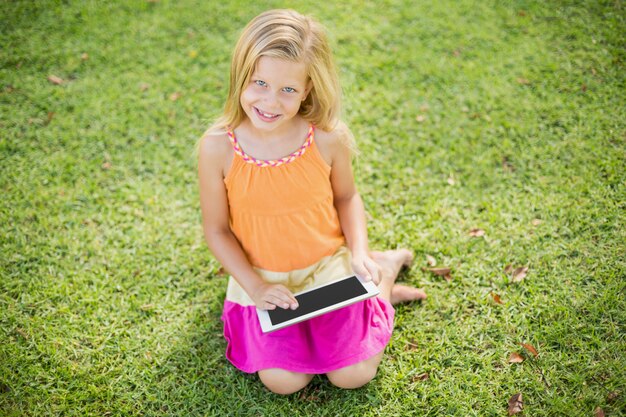 Young girl using digital tablet in park