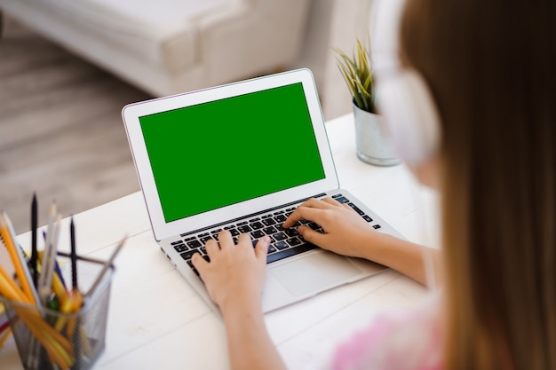 Young girl using laptop for homework at home