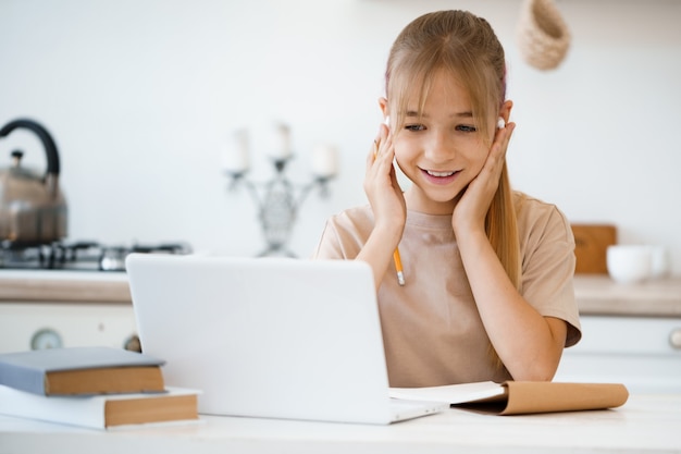 Young girl using laptop for homework at home