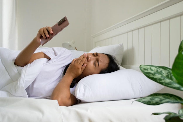 Young girl using mobile phone on bed in bedroom