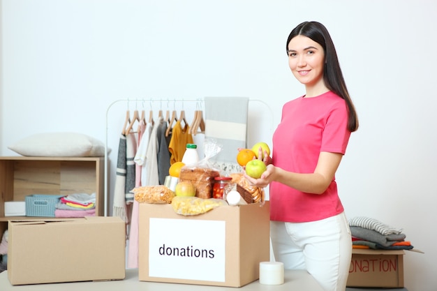 A young girl volunteer collects a box of donations for those in need