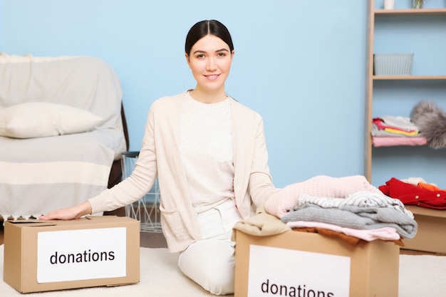 A young girl volunteer collects a box of donations for those in need