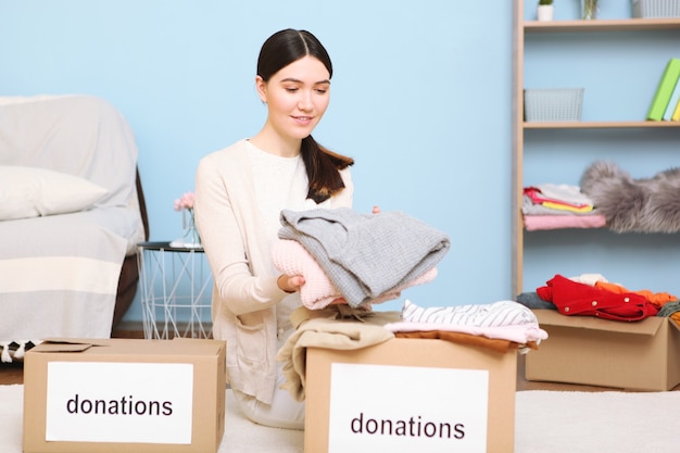 A young girl volunteer collects a box of donations for those in need