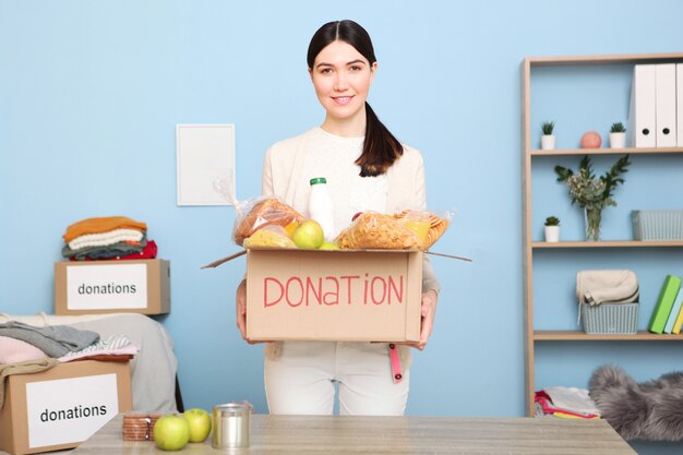 A young girl volunteer collects a box of donations for those in need