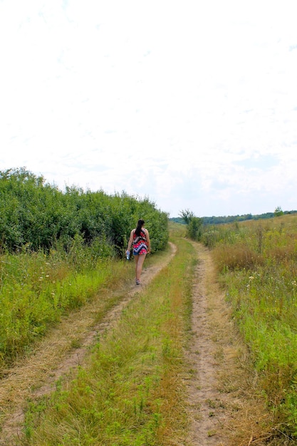 Young girl walking away on the rural road