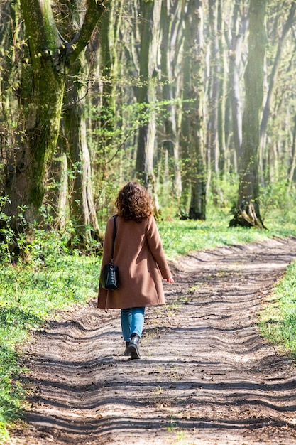 Ragazza che cammina su una strada forestale