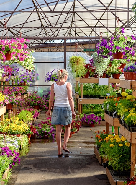 Young girl walks barefoot through a garden center