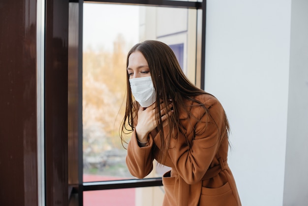 Una ragazza cammina in una maschera durante la pandemia e il coronavirus