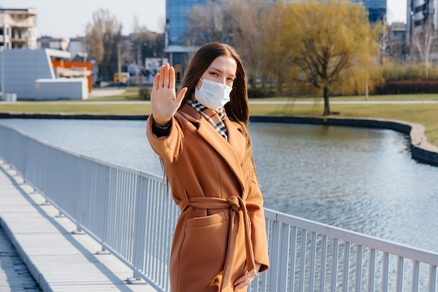 A young girl walks in a mask during the pandemic and coronovirus. Quarantine