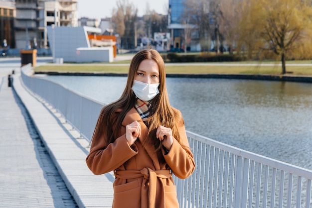 A young girl walks in a mask during the pandemic and coronovirus.