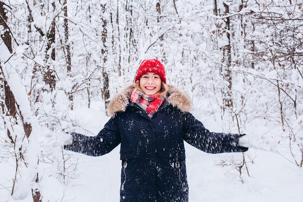 A young girl walks in a snowy, winter forest