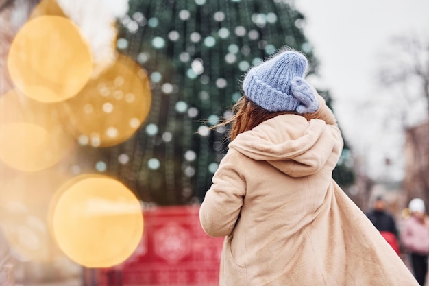 Young girl in warm clothes have a walk outdoors in the city.