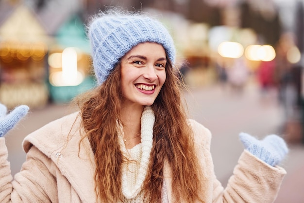 Young girl in warm clothes have a walk outdoors in the city.