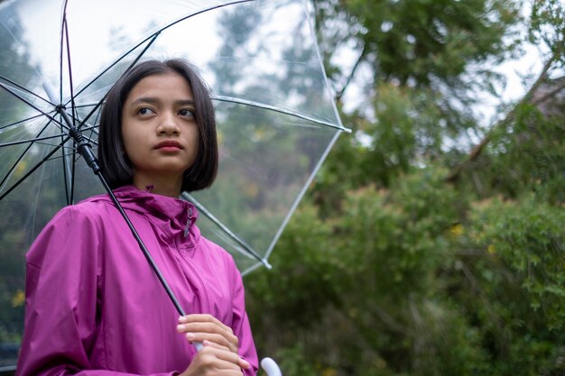 Young girl wear pink coatrain in rain.