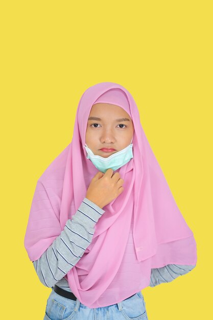 Young girl wear pink hijab on yellow background