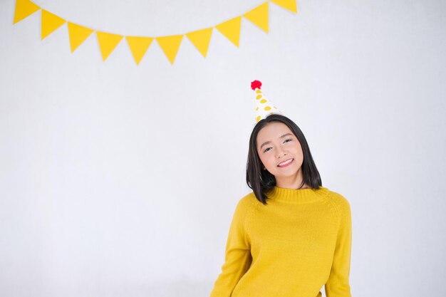 Молодая девушка носит желтый свитер на фоне вечеринки