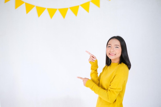 Young girl wear yellow sweater on party background