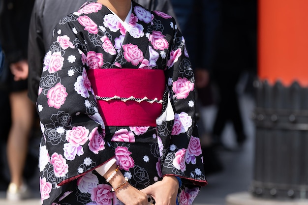 Foto giovane ragazza che indossa un kimono giapponese in piedi davanti al tempio sensoji a tokyo giappone il kimono è un indumento tradizionale giapponese la parola kimono che in realtà significa una cosa da indossare