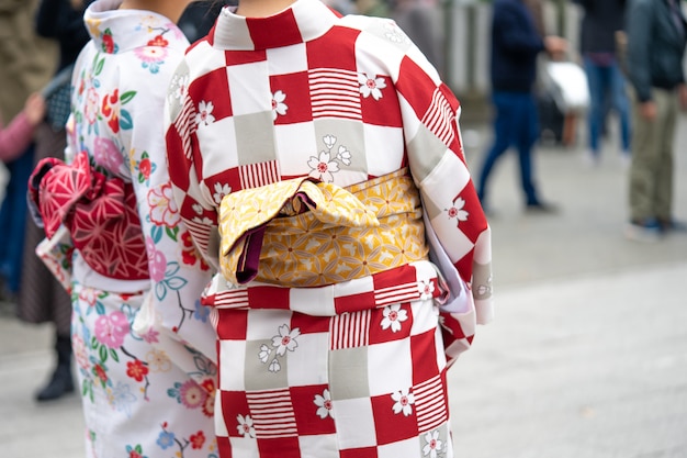 東京の浅草寺の前に日本の着物姿の地位を着た少女