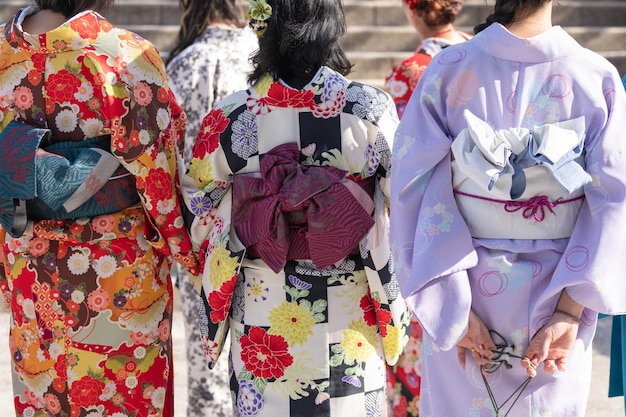 写真 日本のキモノを着た少女が東京のセンソジ寺院の前で立っています 日本の伝統的な衣装です キモノという言葉は実際には着るものという意味です