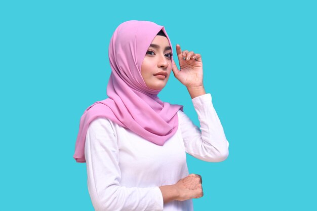 young girl wearing pink hijab posing over blue background indian pakistani model