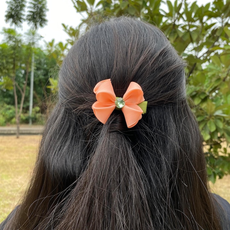फोटो a young girl wearing a valentine bow clip paired with a black hoodie