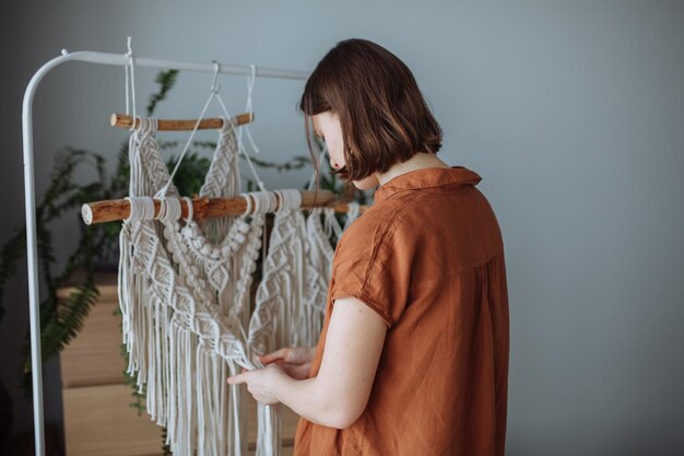 Photo a young girl weaves macrame panels at home