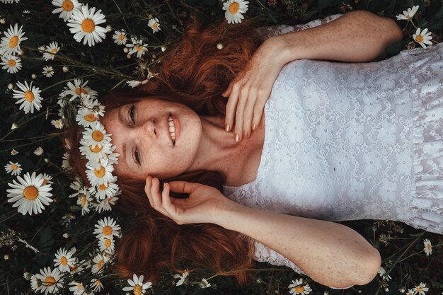 young girl in a white dress in chamomile field