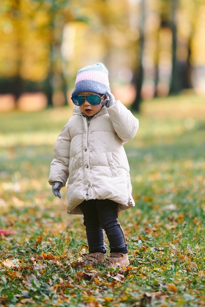 Young girl with adult glasses in the park autumn, funny