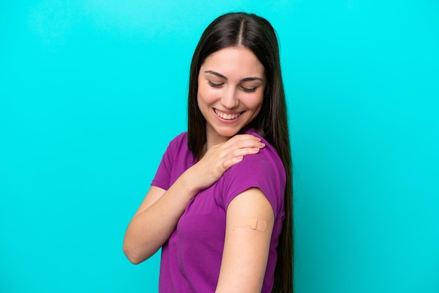 Young girl with bandaids isolated on blue background with happy expression