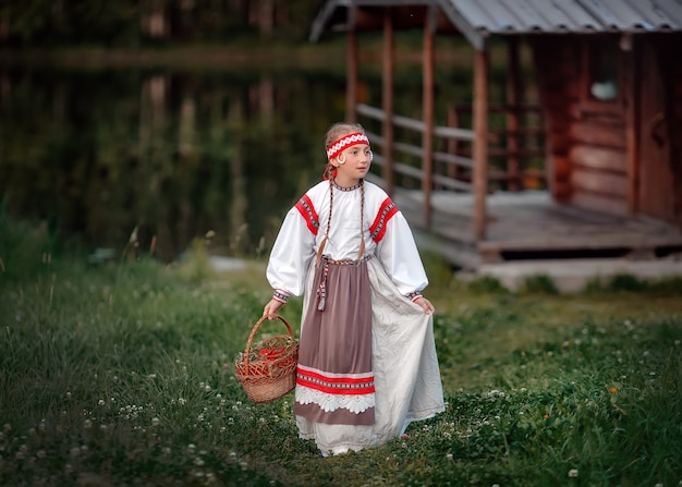 Photo a young girl with a basket of rowan berries in her hands