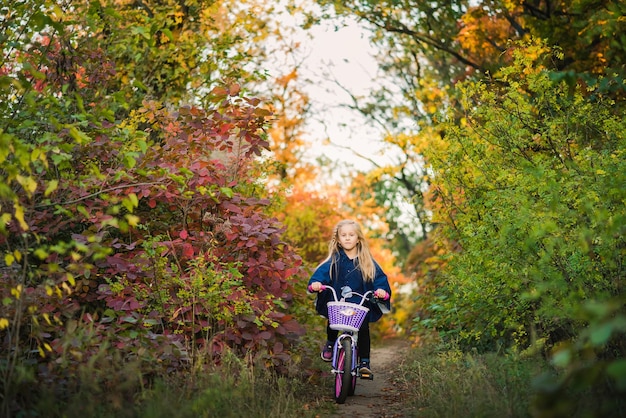 公園で屋外の自転車を持つ少女