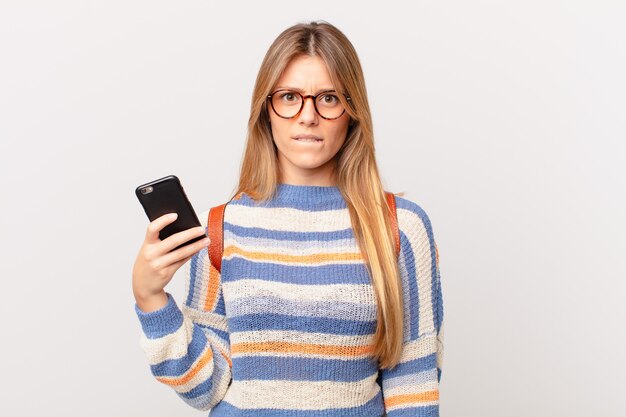 Young girl with a cell looking puzzled and confused