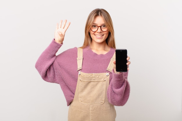 Ragazza con un cellulare che sorride e sembra amichevole, mostrando il numero quattro