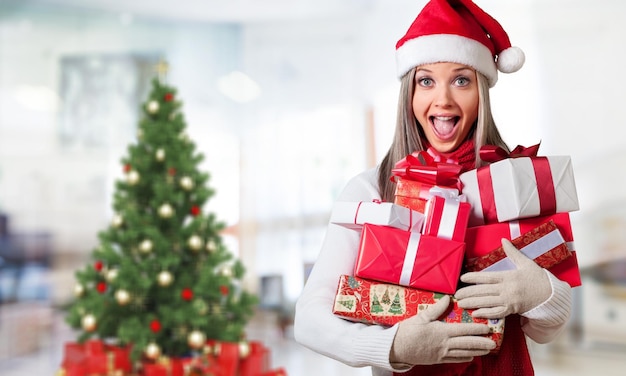 Young girl with christmas gifts on background