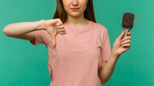 Photo young girl with a comb and problem hair on blue -