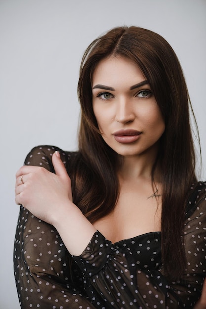 Young girl with dark hair holding her shoulder