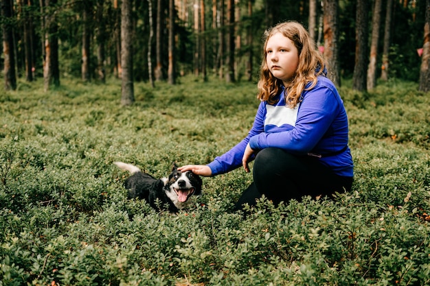 Foto ragazza giovane con il cane in posa nella foresta