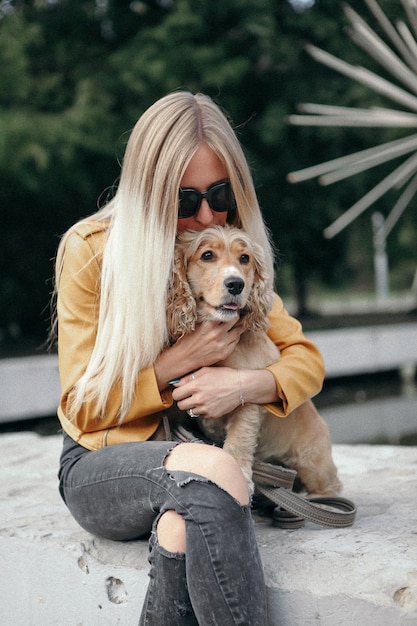 Young girl with dog walks in the park and enjoys the beautiful summer day.